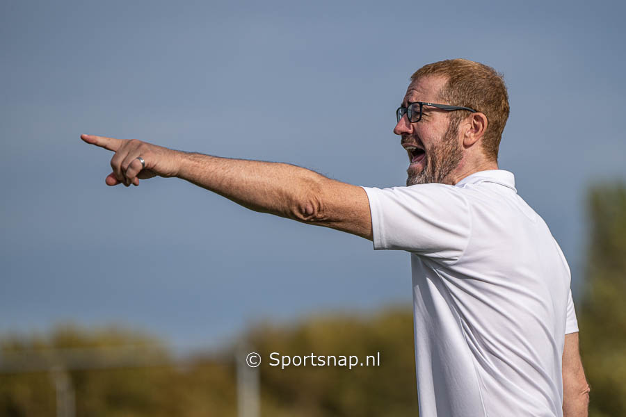 Coach Michael Kirkland van Quick geeft aanwijzingen aan zijn team wat won met 1-9 van HDV voetbal